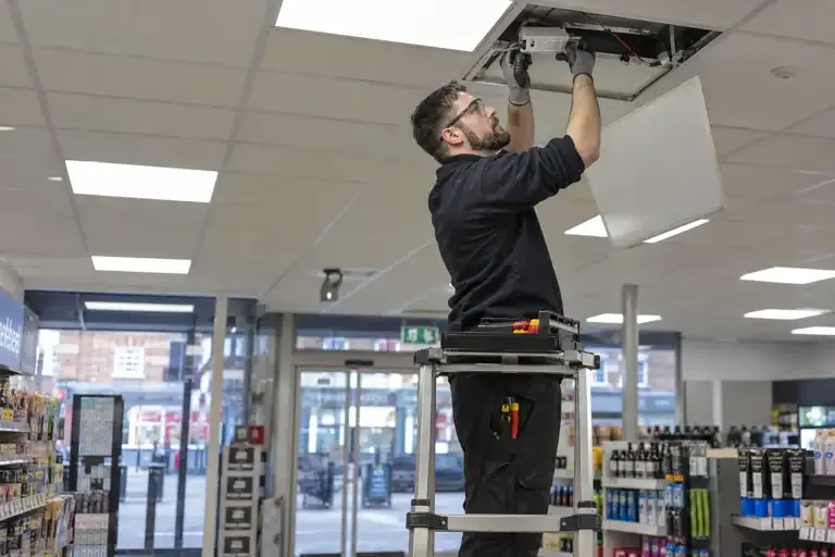 Commercial lighting repairs: a professional electrician assessing or carrying out the electrical work.