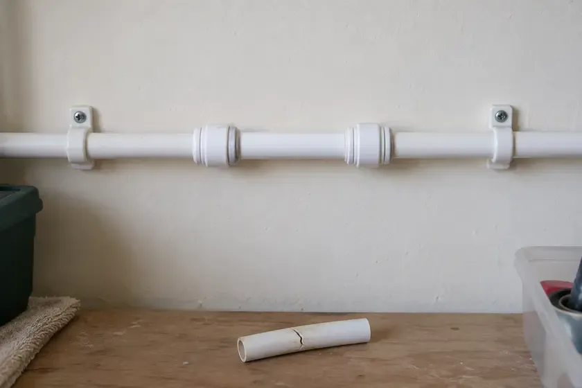 White plastic water supply pipe repaired with push-fit couplings.